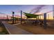A fun outdoor playground with green sunshades offers engaging recreational activities during sunset at 9911 E Telemetry Dr, Mesa, AZ 85212