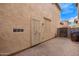 Narrow backyard features side door, hardscape and stucco fencing at 10 N 87Th Dr, Tolleson, AZ 85353