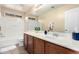 Bathroom with a bath/shower and a wooden vanity with a sink; a tranquil and functional space at 10 N 87Th Dr, Tolleson, AZ 85353