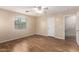 Bright bedroom boasts laminate flooring, neutral walls, a window and a ceiling fan at 10 N 87Th Dr, Tolleson, AZ 85353