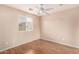 Neutral bedroom features sleek ceiling fan, window, and wood laminate flooring at 10 N 87Th Dr, Tolleson, AZ 85353