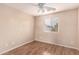 Bedroom features laminate floors, a ceiling fan, neutral paint, and a window providing natural light at 10 N 87Th Dr, Tolleson, AZ 85353