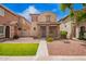Charming two-story home featuring stone accents, a tiled roof, and a well-maintained, low-water landscape at 10 N 87Th Dr, Tolleson, AZ 85353