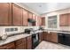 Kitchen featuring wood cabinets, black appliances, and ample counter space at 10 N 87Th Dr, Tolleson, AZ 85353