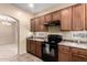 Kitchen with wooden cabinets and black appliances; adjacent to a dining area at 10 N 87Th Dr, Tolleson, AZ 85353