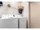 Cozy laundry room with washer, dryer, shelf and decor at 10 N 87Th Dr, Tolleson, AZ 85353