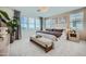 Bright bedroom with a neutral palette, large windows, and a cozy bench at the foot of the bed at 10049 E Ulysses Ave, Mesa, AZ 85212