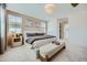 Bright bedroom with a neutral palette, large windows, and a cozy bench at the foot of the bed at 10049 E Ulysses Ave, Mesa, AZ 85212