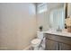Stylish powder room with modern wallpaper, white fixtures, and a dark wood vanity at 10049 E Ulysses Ave, Mesa, AZ 85212