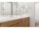 Modern bathroom featuring double vanity with sleek white countertops and wood cabinetry at 10156 E Talon Ave, Mesa, AZ 85212