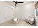 Minimalist bedroom featuring a chair, fan, closet and neutral color palette at 10156 E Talon Ave, Mesa, AZ 85212