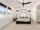 Bright bedroom with large windows, stylish canopy bed, and sleek ceiling fan at 10156 E Talon Ave, Mesa, AZ 85212