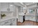 Well-lit kitchen featuring white cabinets, modern hardware, and laminate wood flooring at 10235 N 31St St # 15, Phoenix, AZ 85028