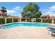 Community pool is fenced and features mature landscaping and chairs at 10235 N 31St St # 15, Phoenix, AZ 85028