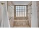 Elegant tiled shower with a built-in bench, glass block window, and convenient grab bar at 10235 N 31St St # 15, Phoenix, AZ 85028