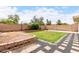 Expansive backyard with defined spaces including a grass area, garden beds, gravel, and a decorative stone pathway at 1130 W Kingbird Dr, Chandler, AZ 85286