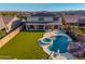 Expansive backyard with synthetic grass, a pool, spa, and covered patio for outdoor enjoyment and entertaining at 11844 W Nadine Way, Peoria, AZ 85383