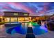 A luxurious backyard features a stunning pool with waterfall and spa under a colorful sunset sky at 11844 W Nadine Way, Peoria, AZ 85383