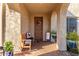 Inviting covered porch with charming decor, arched entryway, and cozy bench seating on a sunny day at 11844 W Nadine Way, Peoria, AZ 85383