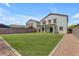 Spacious backyard showcasing lush green grass, stone accents, and rear house view at 1237 W Agrarian Hills Dr, San Tan Valley, AZ 85143