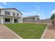Lush backyard features green grass, stone accents, and views of the beautiful two-story home at 1237 W Agrarian Hills Dr, San Tan Valley, AZ 85143