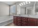 Bright bathroom with double sinks, a large mirror, and a separate tub and shower combination at 1237 W Agrarian Hills Dr, San Tan Valley, AZ 85143