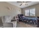 A cozy bedroom with a unicorn themed bedspread, a chair, and plenty of natural light at 1237 W Agrarian Hills Dr, San Tan Valley, AZ 85143