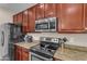 Close-up of kitchen featuring stainless steel microwave and oven, granite countertops and dark cabinets at 1237 W Agrarian Hills Dr, San Tan Valley, AZ 85143