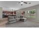 Open living room showcasing a large window, a gray sofa, and a view into the kitchen at 1237 W Agrarian Hills Dr, San Tan Valley, AZ 85143
