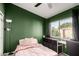 Well-lit bedroom with a window view, ceiling fan, and charming, green accent wall at 125 S 56Th St # 36, Mesa, AZ 85206