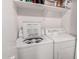 Efficient laundry area featuring a washing machine, dryer, and storage shelves at 125 S 56Th St # 36, Mesa, AZ 85206