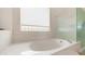 Close up of a bathtub and step-in shower with privacy glass window at 14033 S 31St St, Phoenix, AZ 85048