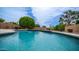A close-up of an in-ground pool with blue water, surrounded by landscaping and a patio area at 14033 S 31St St, Phoenix, AZ 85048