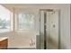 Bright bathroom featuring a soaking tub, tiled shower, and large window at 150 N Nielson St, Gilbert, AZ 85234