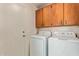 Laundry room with full-sized washer and dryer units, complete with overhead storage at 150 N Nielson St, Gilbert, AZ 85234