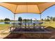 Picnic area with shaded structure overlooking a beautiful pond with lush landscaping at 150 N Nielson St, Gilbert, AZ 85234