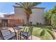 Backyard showing a grass area with palm tree and patio set with a table and chairs at 15550 N Frank Lloyd Wright Blvd # 1101, Scottsdale, AZ 85260