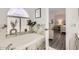 Bright bathroom features a soaking tub with marble surround next to bedroom doorway and wood floors at 15550 N Frank Lloyd Wright Blvd # 1101, Scottsdale, AZ 85260
