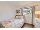 Cozy bedroom with a pink bed, hardwood floors, and natural light from window at 15550 N Frank Lloyd Wright Blvd # 1101, Scottsdale, AZ 85260