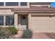 Charming entrance with a gray front door, desert landscaping, and a two-car garage at 15550 N Frank Lloyd Wright Blvd # 1101, Scottsdale, AZ 85260