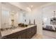 Bathroom showcasing a double sink vanity with granite countertops and mirrors with views into the bedroom at 15791 W Kendall St, Goodyear, AZ 85338