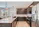 Elegant kitchen with dark cabinetry, stainless steel appliances, and a large granite island at 15791 W Kendall St, Goodyear, AZ 85338