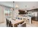 Stylish kitchen and dining area with dark wood cabinets, stainless steel appliances, and a spacious island at 15791 W Kendall St, Goodyear, AZ 85338