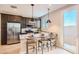 Open-concept kitchen with granite countertops, stainless steel appliances, and a bar area with seating at 15791 W Kendall St, Goodyear, AZ 85338