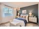 This main bedroom features dark blue accent wall, a bed with bench seating, and nightstands with lamps at 15791 W Kendall St, Goodyear, AZ 85338