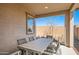 Covered patio featuring a dining table, chairs, and view of the clear sky and backyard landscaping at 15791 W Kendall St, Goodyear, AZ 85338