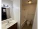 Bright bathroom featuring a tiled shower-tub combo, vanity sink with mirror, and tiled floors at 16602 N 25Th St # 217, Phoenix, AZ 85032