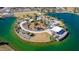 Aerial view of a lush community park with a playground, lakeside pavilion, and walking paths at 18883 E Celtic Manor Dr, Queen Creek, AZ 85142