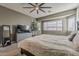 Comfortable bedroom features a ceiling fan, large windows, and calming paint color at 19323 E Canary Way, Queen Creek, AZ 85142