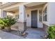 Inviting covered front porch with stone accents, security door, and desert landscaping at 19323 E Canary Way, Queen Creek, AZ 85142